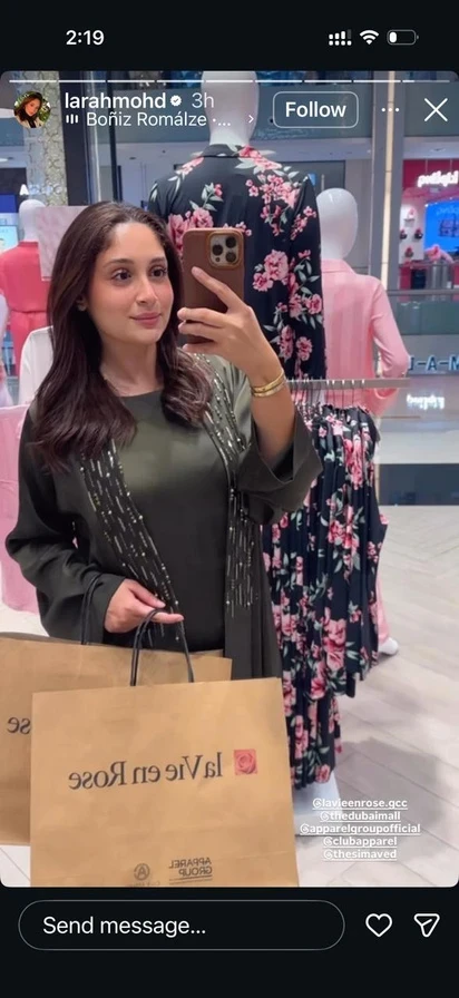 A creator in the store holding a La Vie en Rose shopping bag.