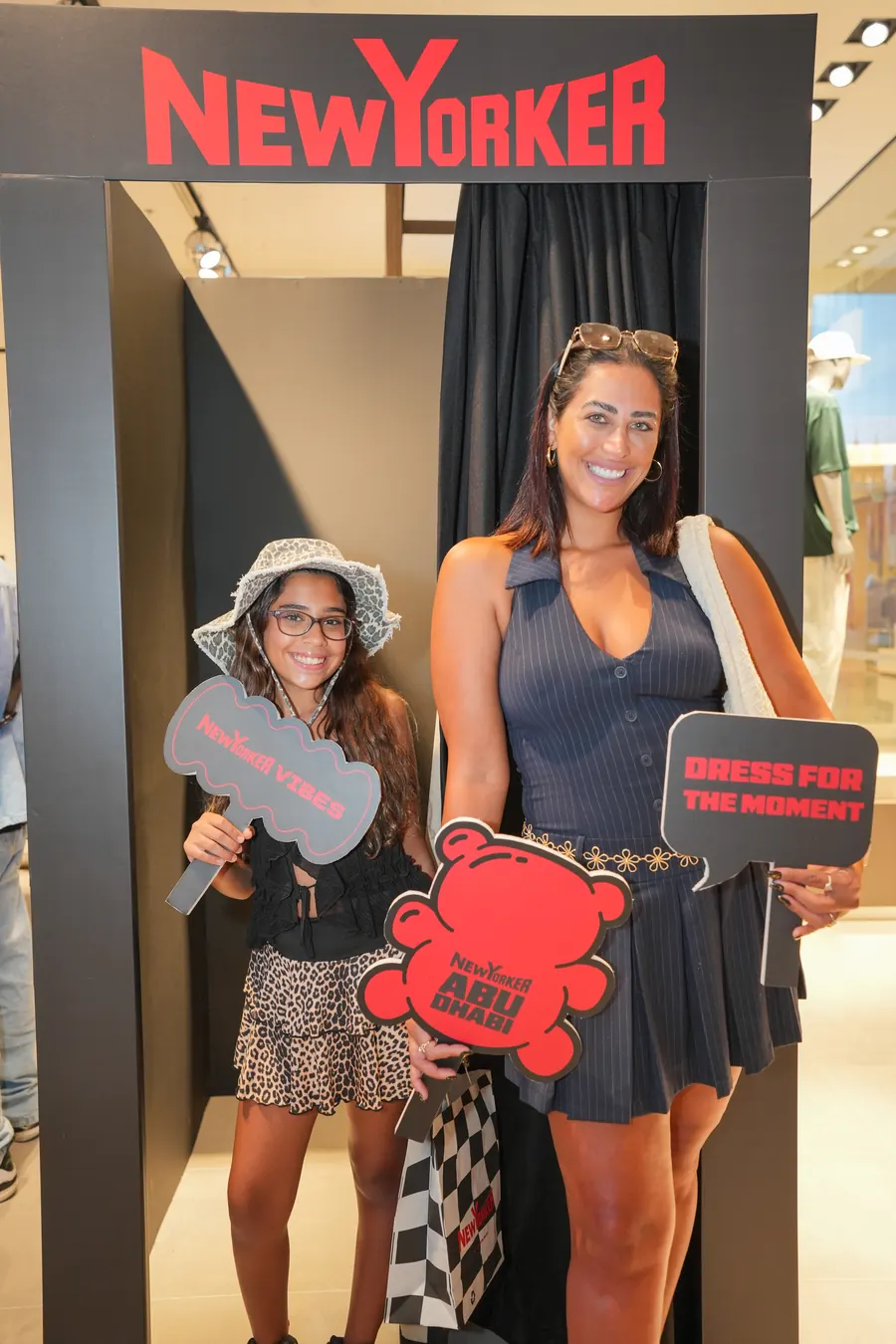 Guests with NEW YORKER props in the fitting-room booth.