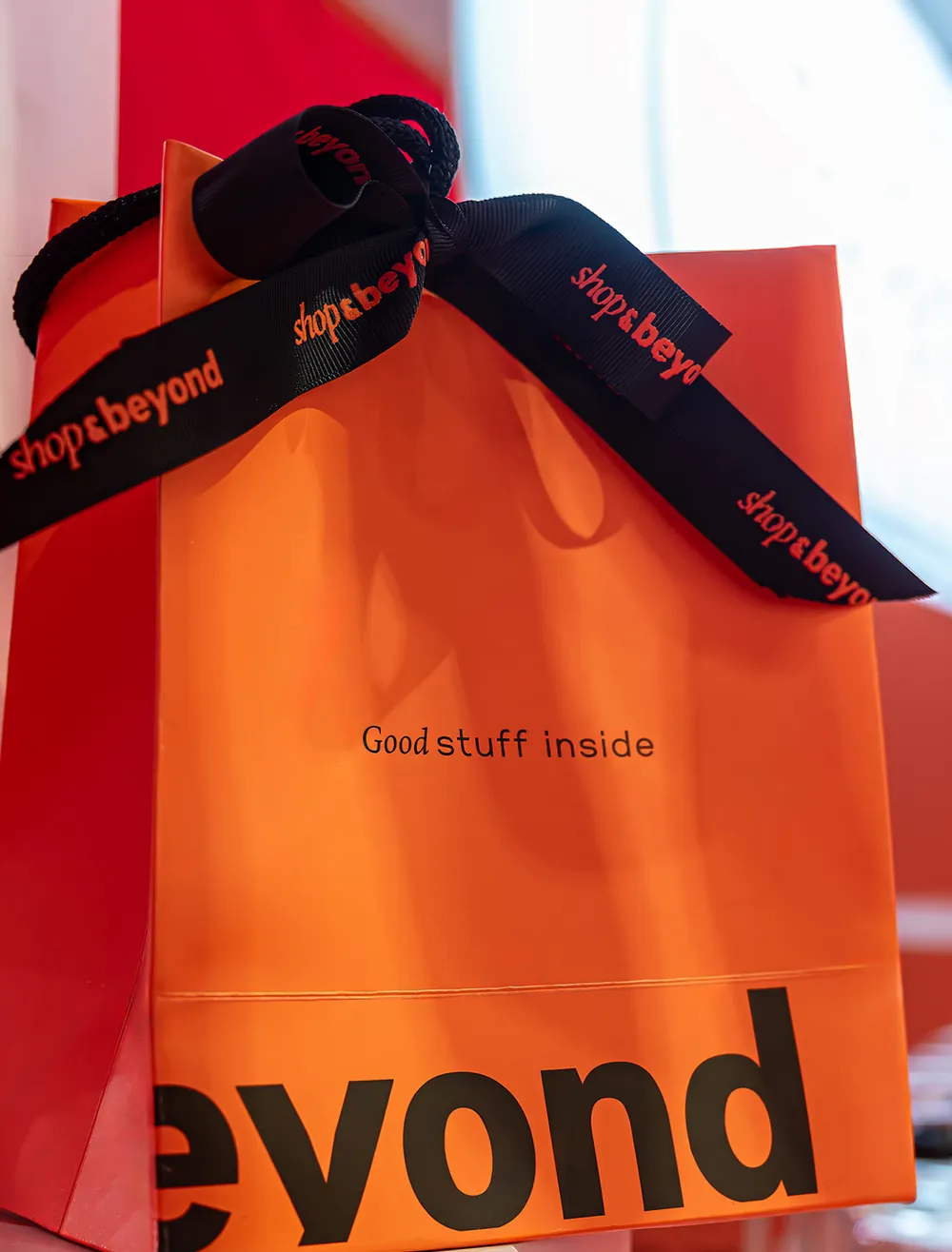 A Shop & Beyond bag tied with its branded ribbon, photographed for the brand’s social stories.